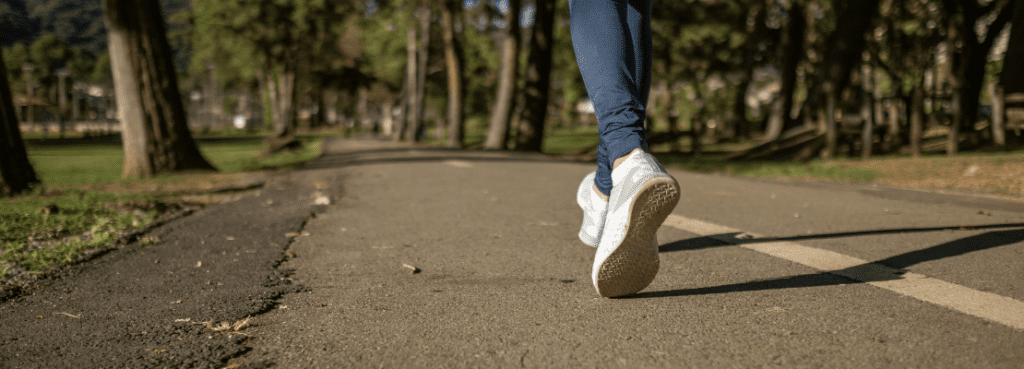 a person's feet in white shoes on a road