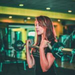 A photo of a woman lifting weights. An image that highlights the benefits of strength training for women.
