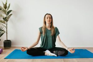 A person meditating in a calm home environment, sitting comfortably and reflecting mental peace.