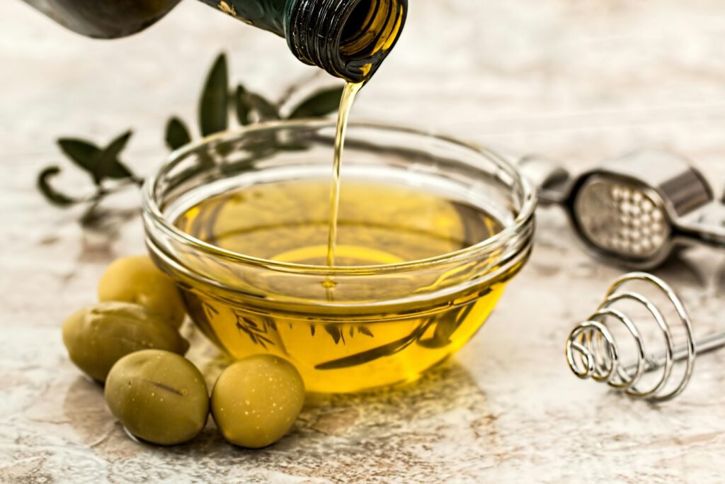 A photo of healthy fats like avocado, almonds, and olive oil. It represents healthy fats that are part of a healthy diet.