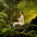 A person meditating in nature.